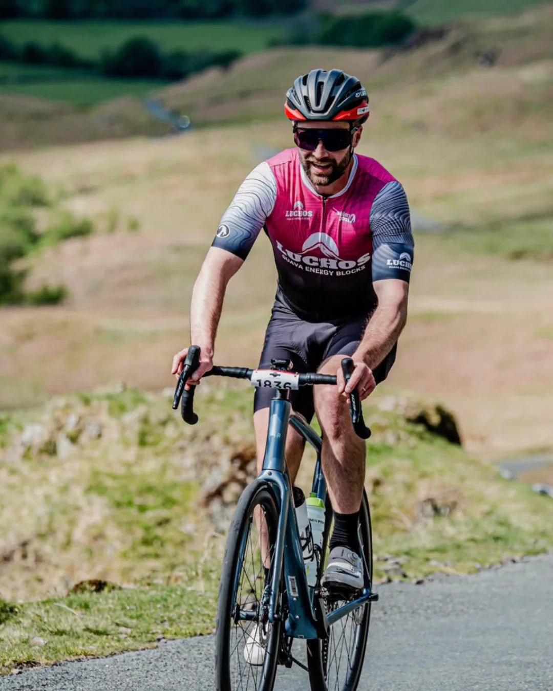 Cyclist in Luchos kit riding a mountain road