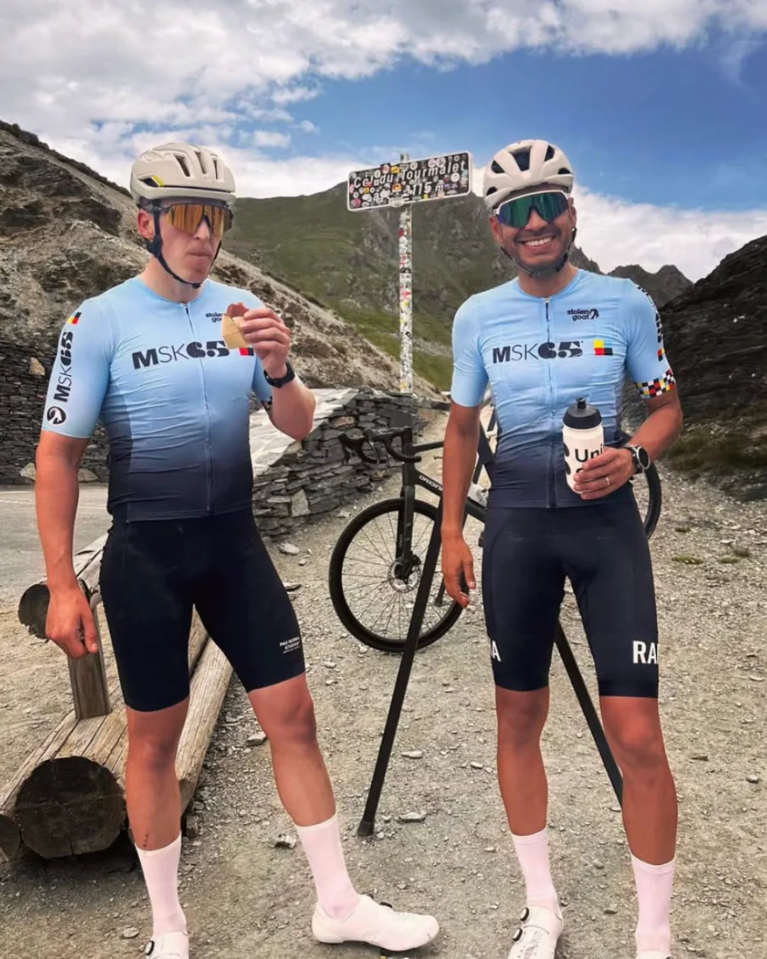 Two cyclists eating Luchos energy blocks at a mountain pass