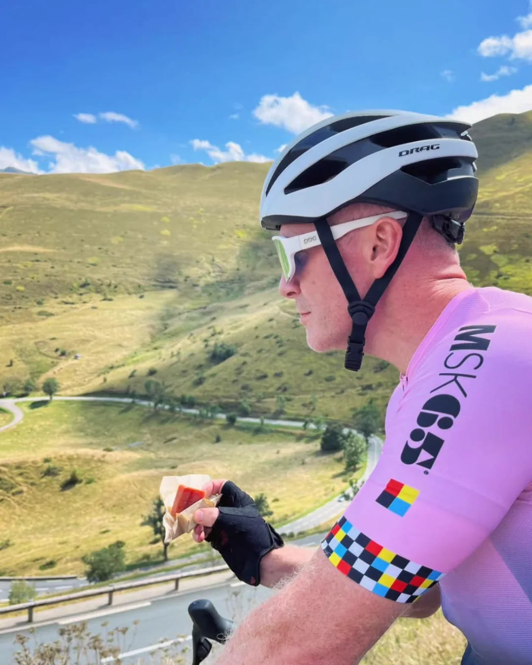 Cyclist eating a Luchos energy block on a climb