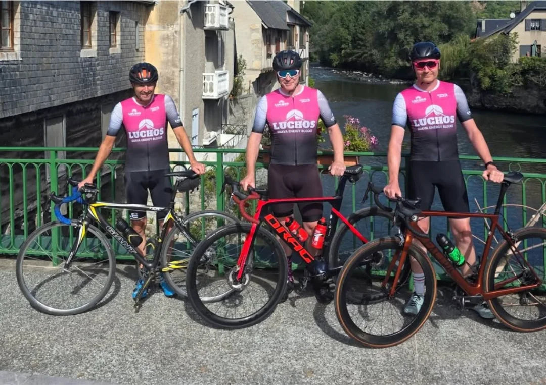 Three cyclists in Luchos kit with their bikes
