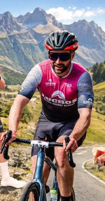Cyclist in a Luchos Guava Energy Blocks jersey on a mountain climb